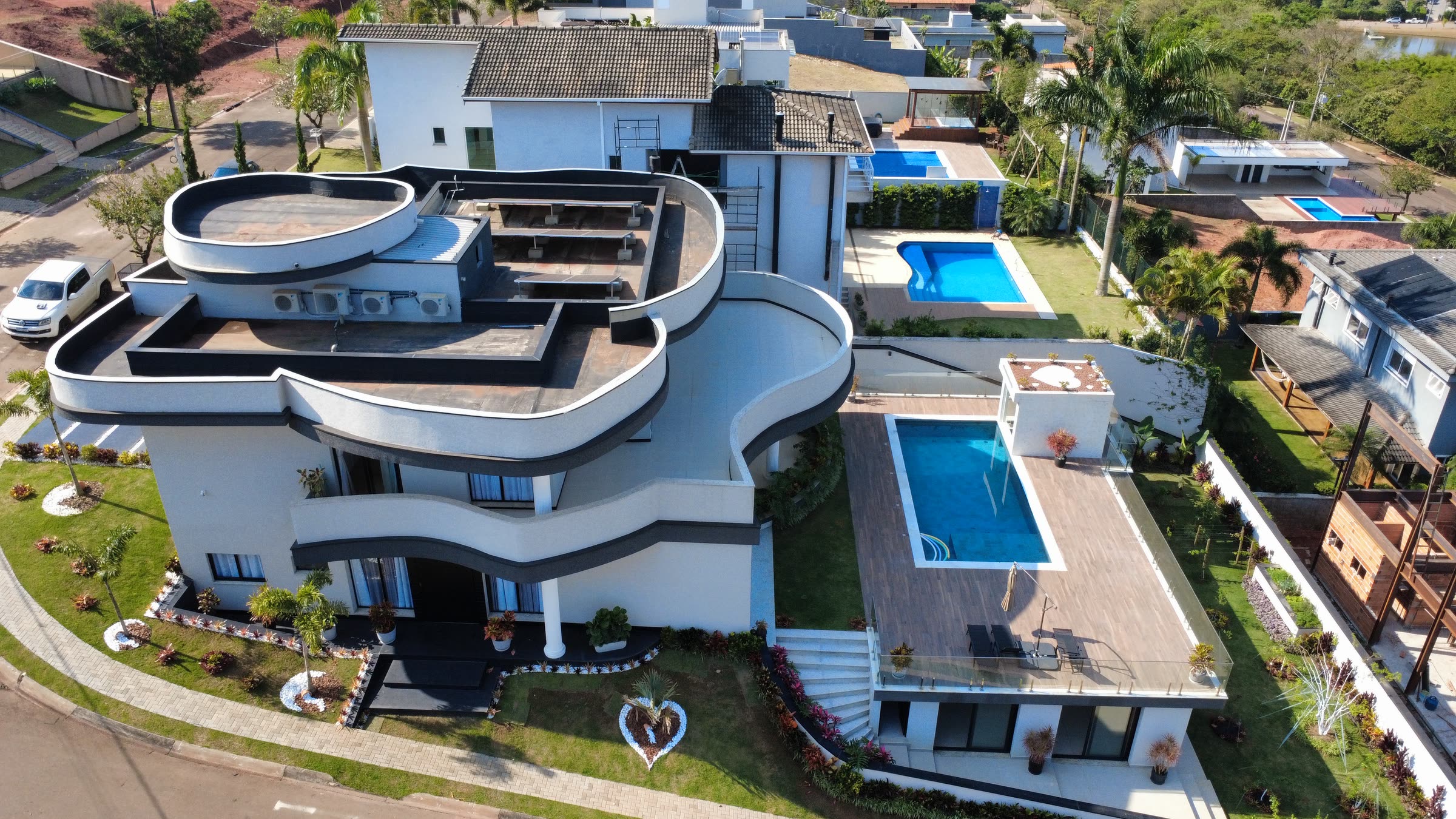 Vista aérea da residência com as varandas curvas, o deque e a piscina
